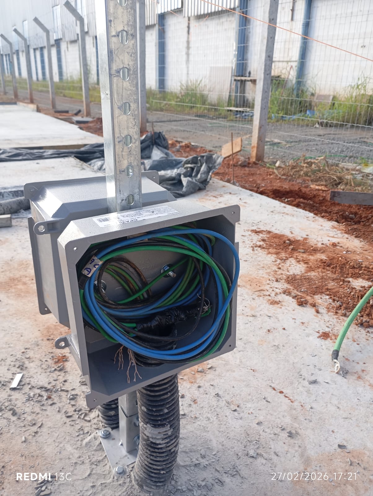 Caixa de distribuição em poste com cabos organizados em obra externa